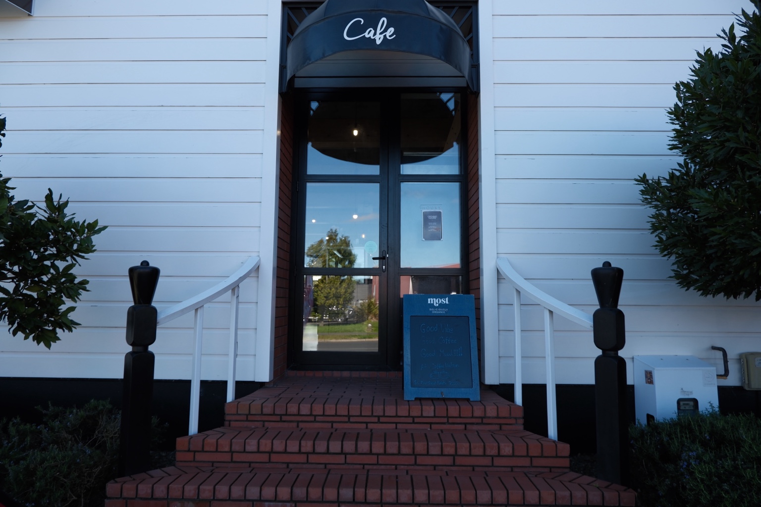 Coffee Nation café entrance with brick steps and a café awning